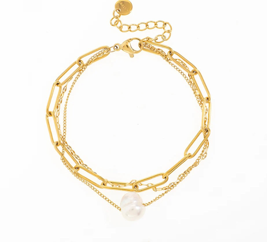 Ce bracelet triple, en acier inoxydable et plaqué or, allie différentes textures pour un look unique et tendance. Il se compose d'une chaîne en maille urbaine épaisse, d'une chaîne en maille urbaine fine, et d'une chaîne délicate avec une véritable perle d'eau douce en son centre. Un mélange parfait de style et d'élégance, idéal pour sublimer ton poignet avec une touche de sophistication moderne.