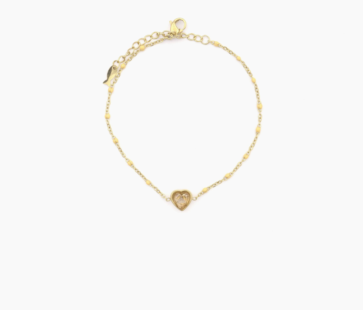 Bracelet Ella en maille fine parsemée de petite boule orangé très léger. Au centre un cœur en zircon de la même couleur. Ce bracelet est en acier inoxydable et plaqué or.