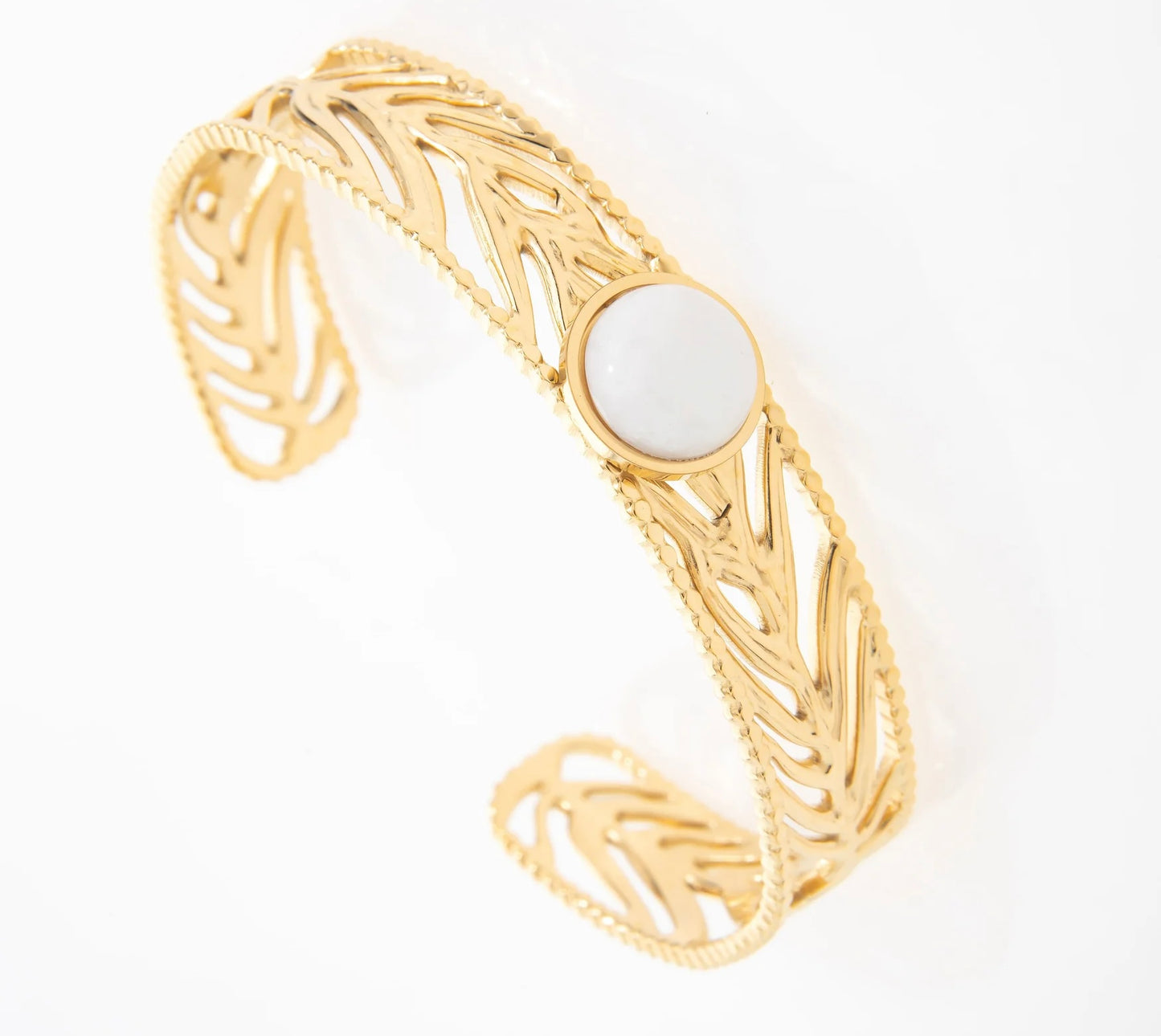 Jonc moyennement épais, avec feuille de palmier dans le jonc tout autour. Au centre un pierre de quartz blanc