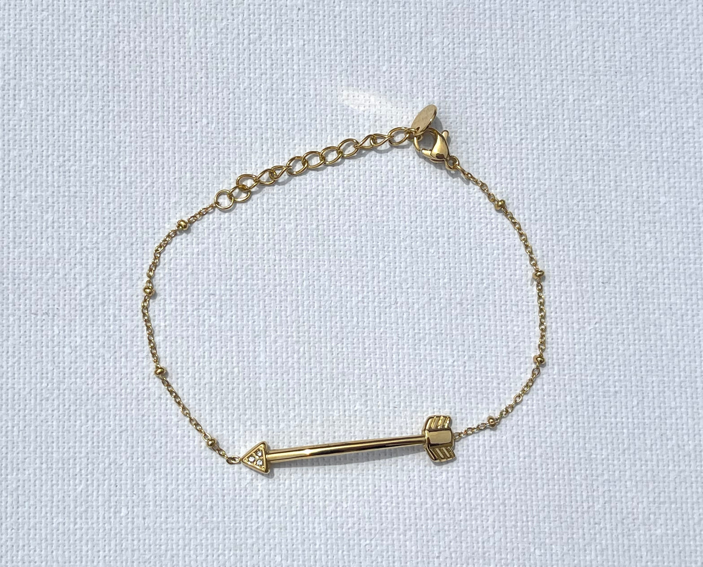 Bracelet Emmy en maille fine, en acier inoxydable et plaqué or, agrémenté de petites boules délicates. Au centre, une flèche avec des zircons étincelants incrustés dans sa pointe. Un bijou chic et raffiné, parfait pour ajouter une touche de brillance subtile à votre poignet.