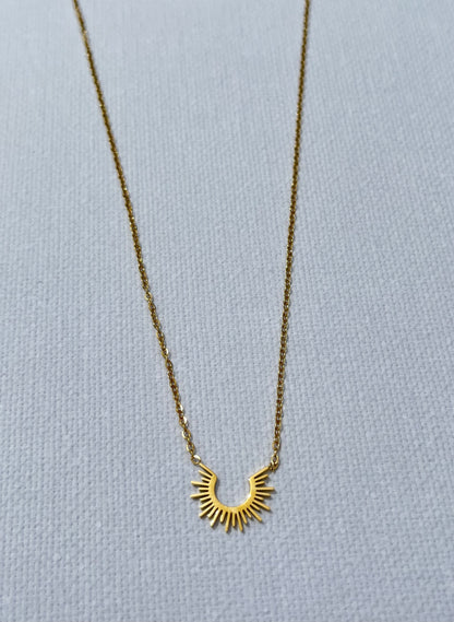 Découvre notre collier au charme solaire, en acier inoxydable et plaqué or. Ce bijou fin est composé d'une chaîne de type forçat. Son pendentif en forme de demi-soleil apporte une touche de lumière à ton décolleté. Chic, minimaliste et facile à porter, ce collier est le must-have pour toutes les femmes qui aiment se démarquer tout en restant élégantes. Craque pour ce bijou qui fera rayonner ton style.