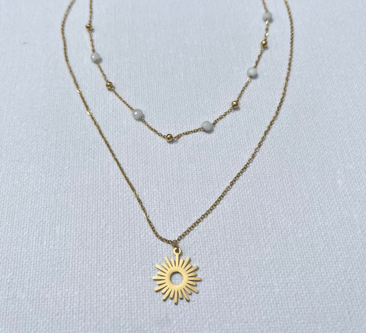 Craque pour ce bijou chic, en acier inoxydable et plaqué or, qui ne manquera pas de sublimer toutes tes tenues. Ce collier à double chaîne joue sur les contrastes avec finesse : une chaîne perlée délicate, agrémentée de petites perles blanches et de mini billes dorées, s’accorde parfaitement avec une chaîne plus simple et épurée, portant un pendentif en forme de soleil rayonnant. N'attends plus, ajoute cette pépite à ton panier et prépare-toi à rayonner !