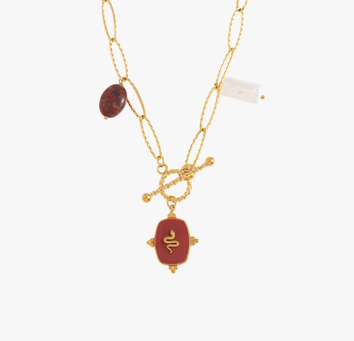 Un collier, en acier inoxydable et plaqué or, qui sort du lot. La chaîne épaisse en mailles ovales et les pierres naturelles apportent une touche d’authenticité : jaspe, quartz, et ce pendentif rouge profond orné d’un serpent doré, symbole de puissance et de transformation. Le fermoir T qui se ferme à l’avant, ajoute une touche stylée et pratique. Un bijou audacieux, pour une femme audacieuse.