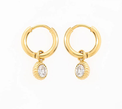 Craque pour ces élégantes boucles d'oreilles créoles, en acier inoxydable et plaqué or, qui sublimeront ton look en un clin d'œil. Chaque anneau arbore un pendentif délicatement serti d'une pierre de zirconium. Adopte-les pour briller en toutes circonstances, et laisse ces créoles rehausser ton style avec une pointe d’élégance.