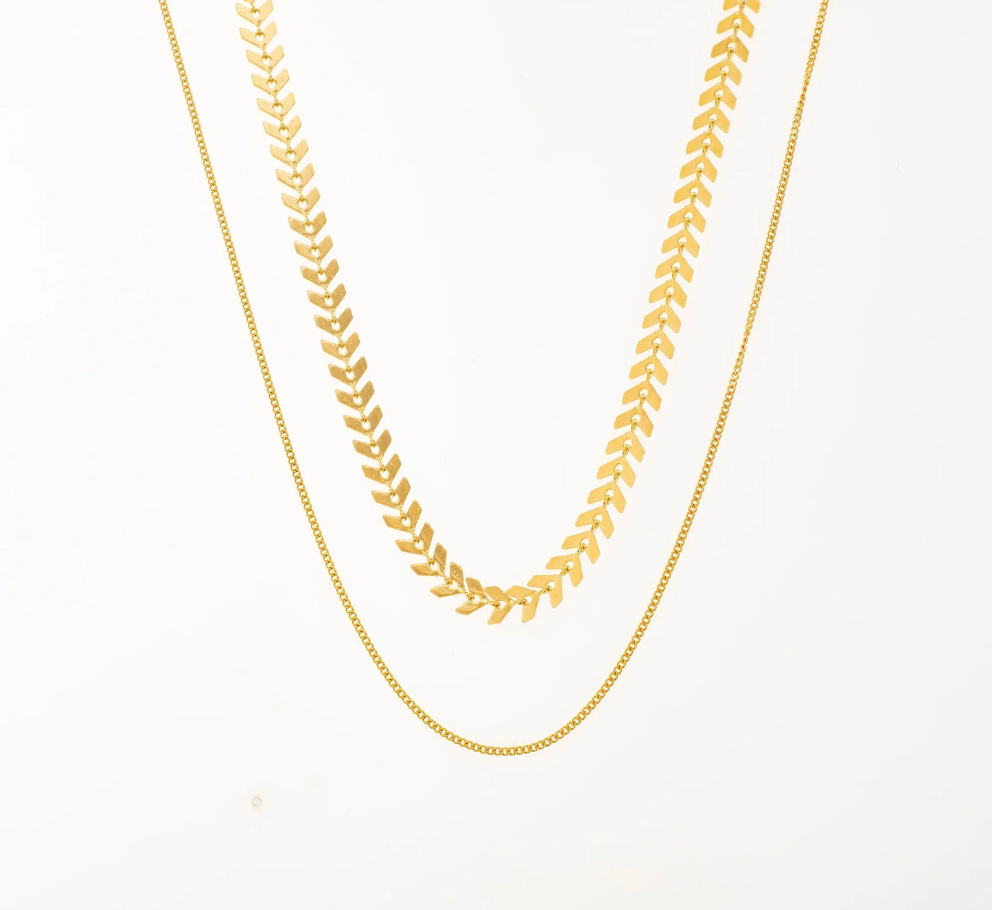 Ajoute une touche d'élégance à ton look avec ce collier à double chaîne, en acier inoxydable et plaqué or, parfait pour les femmes qui aiment le style épuré mais sophistiqué. Le premier rang est une chaîne chevron, connue pour sa fluidité et son éclat. La seconde chaîne en maille forçat, légère et discrète, idéale pour un look minimaliste mais chic. Ce collier est un véritable must-have pour te sublimer au quotidien !