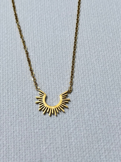 Découvre notre collier au charme solaire, en acier inoxydable et plaqué or. Ce bijou fin est composé d'une chaîne de type forçat. Son pendentif en forme de demi-soleil apporte une touche de lumière à ton décolleté. Chic, minimaliste et facile à porter, ce collier est le must-have pour toutes les femmes qui aiment se démarquer tout en restant élégantes. Craque pour ce bijou qui fera rayonner ton style.