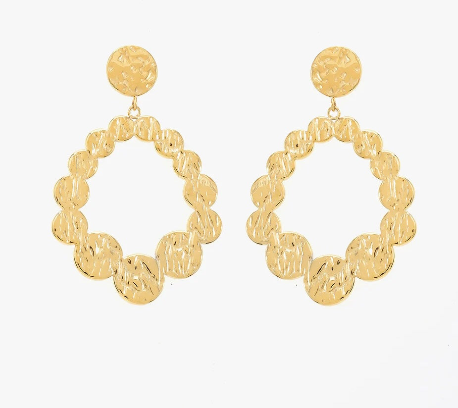 Ces boucles d'oreilles, en acier inoxydable et plaqué or, sont faites pour celles qui osent affirmer leur style. Inspirées des formes organiques et des textures martelées. Composées de larges cercles irréguliers. Leurs motifs circulaires imbriqués forment un ovale original. La partie supérieure est un bouton rond également texturé. Ces boucles d'oreilles incarnent la féminité : fortes, audacieuses, et lumineuses. Associe-les à des cheveux relevés pour un effet maximal !