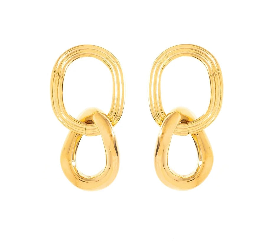 Boucles d’oreilles en acier inoxydable et plaqué or. Le design se compose de deux maillons distincts mais complémentaires. Le premier, de forme ovale, arbore une texture délicatement rainurée. Ces fines rainures, apportent une profondeur visuelle et un relief subtil. Le second maillon, plus large et de forme arrondie, contraste parfaitement avec le premier. Sa surface lisse, offre une brillance miroir. Cette finition impeccable confère au bijou une allure luxueuse et intemporelle. 