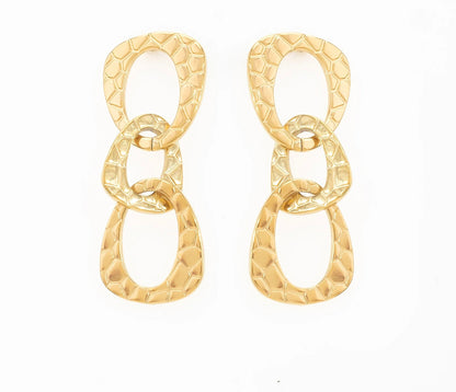 Ces boucles d'oreilles martelé, en acier inoxydable et plaqué or, sont parfaites pour un look affirmé ! Avec leurs trois maillons entrelacés, elles apportent une touche de glamour à n’importe quelle tenue. Que ce soit pour une soirée ou pour un look quotidien, ces boucles d'oreilles deviendront ton accessoire signature.