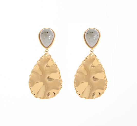 Succombe au charme de ces boucles d'oreilles, en acier inoxydable et plaqué or. Chaque boucle est composée d'une pierre naturelle de labradorite en forme de goutte, apportant une touche d'élégance à ton look. Le pendentif, quant à lui, est en forme de goutte texturée, rappelant une feuille délicatement sculptée. Affirme ton style avec cette pièce incontournable qui allie modernité et élégance intemporelle.