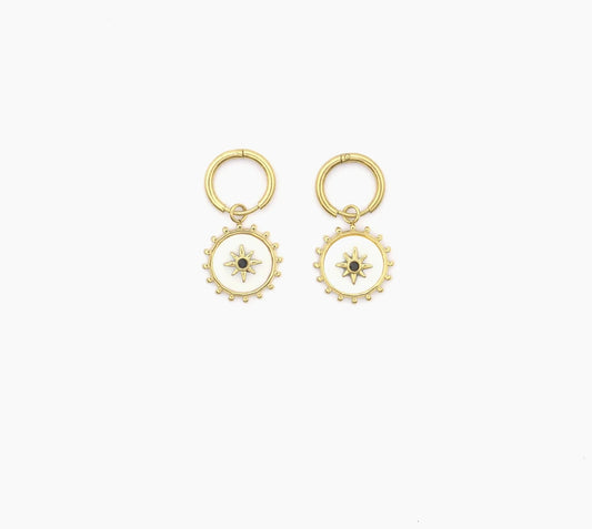 Découvre ces boucles d'oreilles lumineuse, en acier inoxydable et plaqué or. Chaque boucle d'oreille se compose d'un anneau, agrémenté d'un pendentif circulaire blanc nacré orné d'une étoile à huit branches. Le contour du cercle est subtilement décoré de petites perles. Laisse-toi séduire par ces bijoux parfaits pour une femme raffinée.