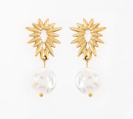 Ose ces boucles d’oreilles, en acier inoxydable et plaqué or, avec un design unique qui allie audace et élégance. La partie supérieure, en forme de soleil, évoque puissance et éclat. Juste en dessous, une élégante perle d’eau douce suspendue. Elles se portent aussi bien seules qu’avec d’autres bijoux pour un effet superposé. C’est l’accessoire parfait pour sublimer ta féminité et affirmer ta personnalité.