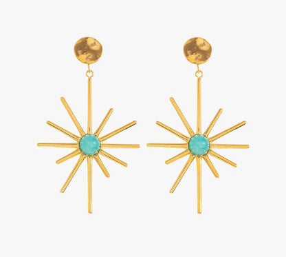 Affirme ton style avec ces boucles d’oreilles pendantes au design solaire, en acier inoxydable et plaqué or. Leurs longues branches finement travaillées, s’ouvrent autour d’une pierre centrale disponible en turquoise ou en blanc nacré. Leur design audacieux est parfait pour la femme qui n’a pas peur de se distinguer.